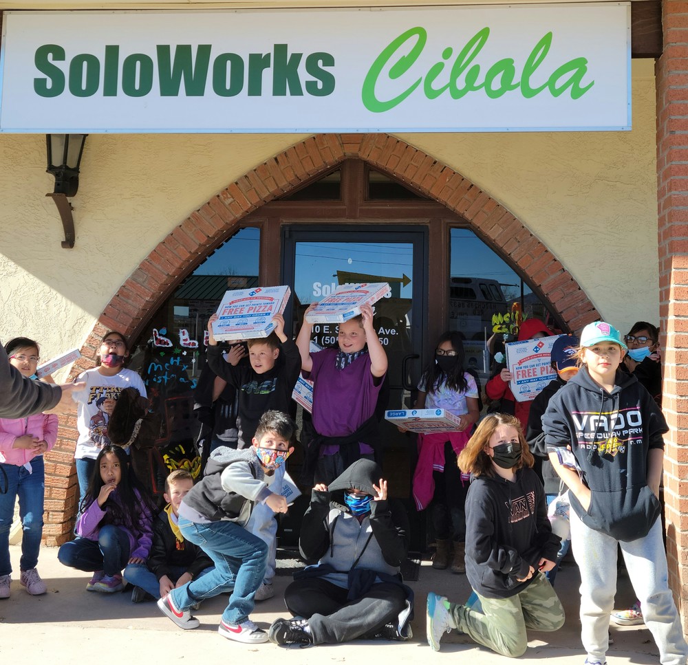 students with pizza boxes green SoloWorks Cibola